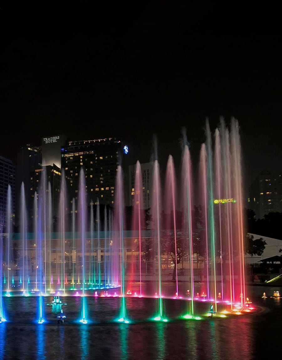 Magenta illuminated fountain at night